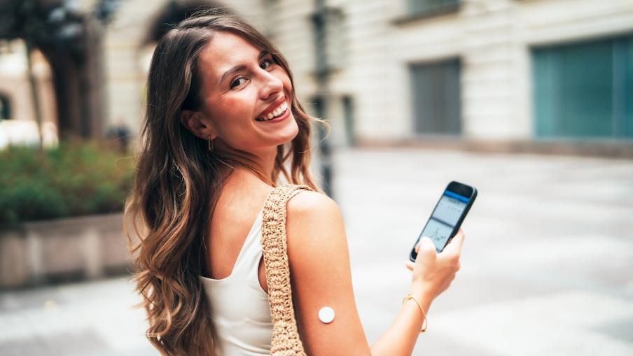 
		Young woman with a CGM sensor and a cell phone
	